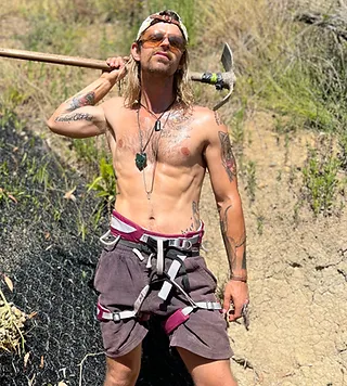 Bo from Down 2 Earth with a pickaxe on a Nelson hillside