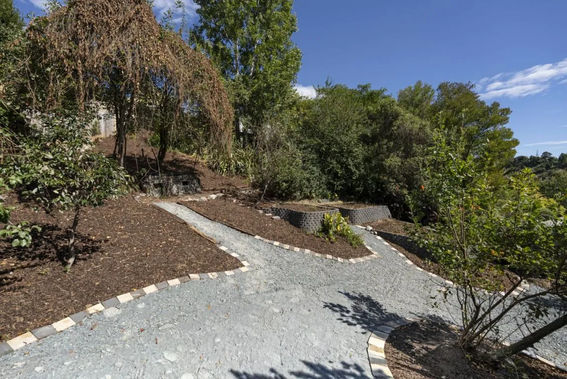 Finished stone path with timber retaining beside a garden